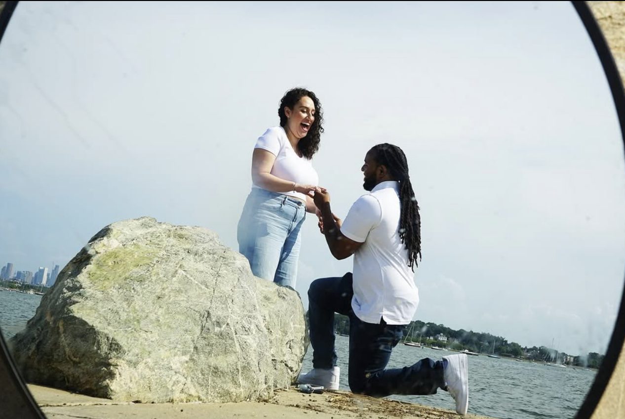 A proposal on the shoreline with the city skyline behind.