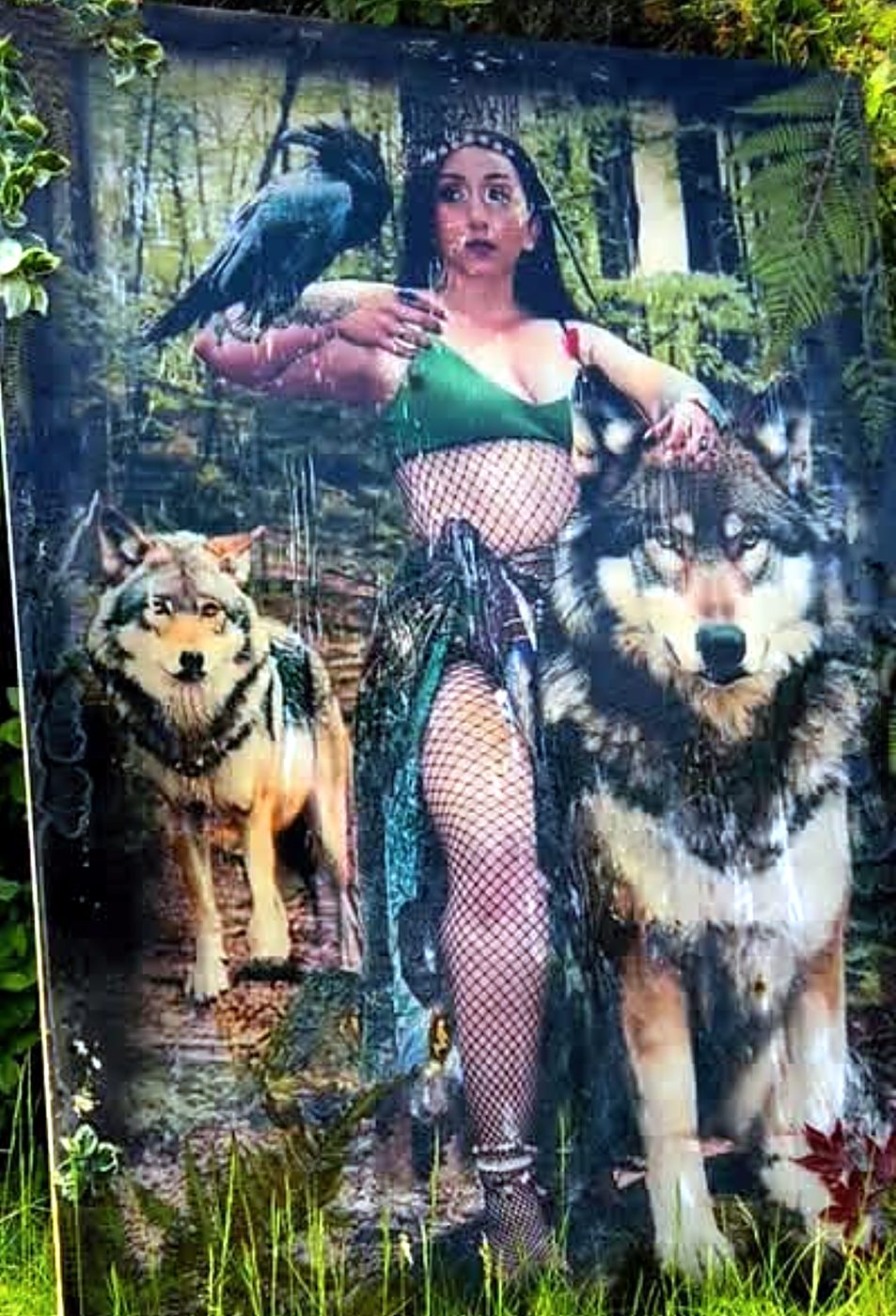 Portrait on wood of a woman in a forest with a raven on her arm and two wolves beside her