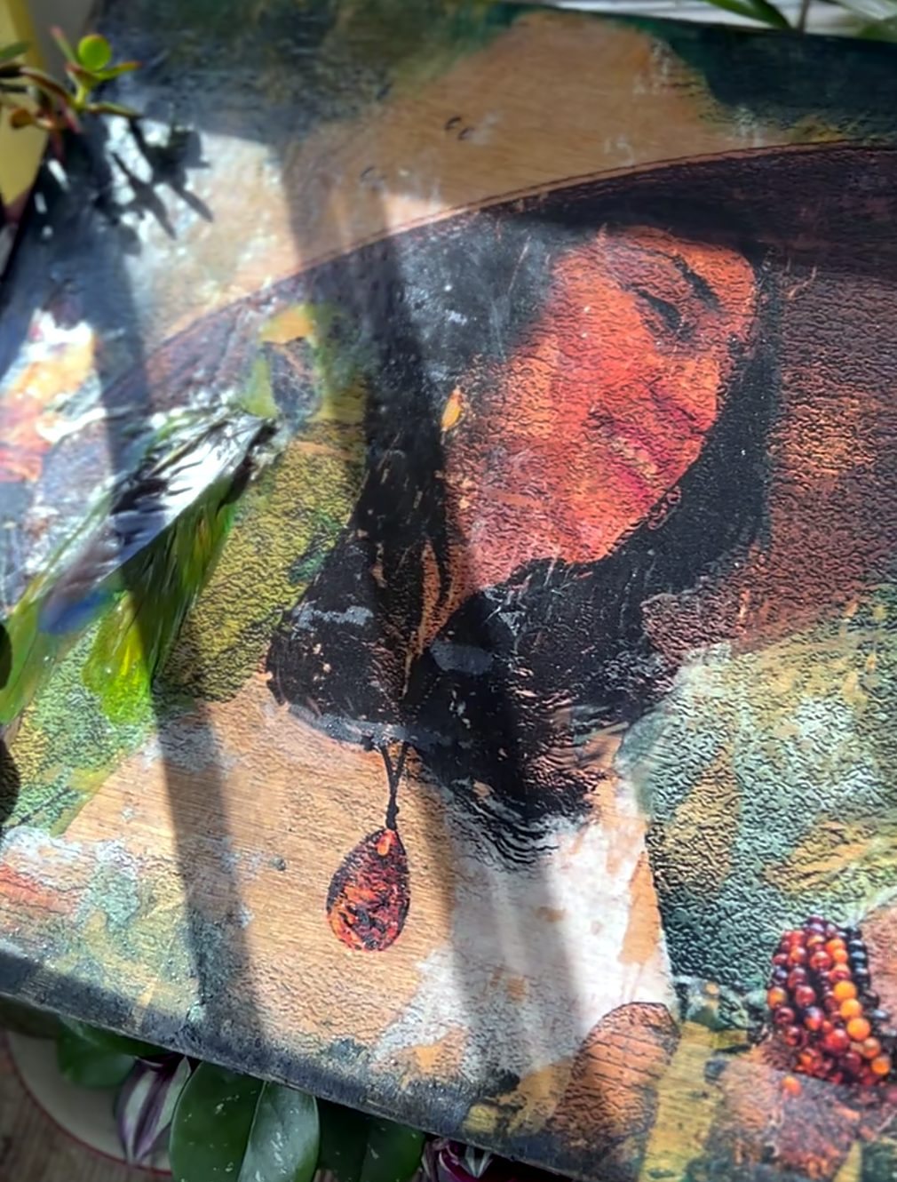 Portrait on wood of a woman in a wide-brimmed hat with an amber pendant, feathers set in resin